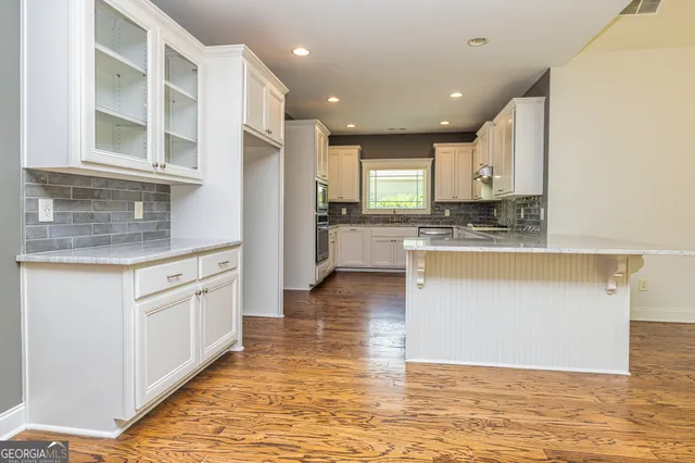 a large kitchen with stainless steel appliances granite countertop a granite counter tops and a window