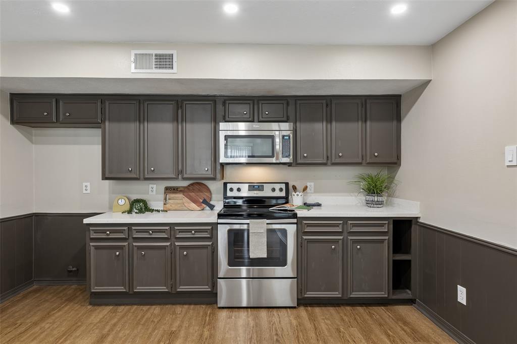 4962 Thunder Road Dallas, TX 75244 - Photo 9 of 26 Kitchen featuring wood-finish flooring, dark cabinetry, light countertops, stainless steel appliances, and recessed lighting
