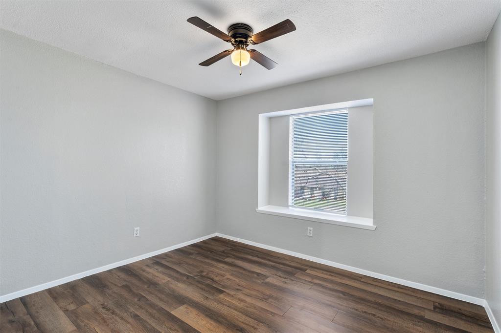 1711 Rawhide Loop Round Rock, TX 78681 - Photo 9 of 14 Unfurnished room featuring dark wood-type flooring, ceiling fan, and a textured ceiling