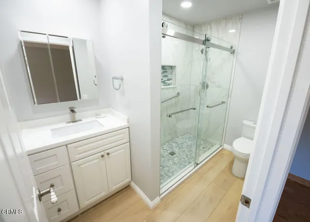 a bathroom with a shower sink and mirror