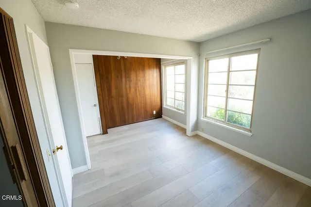 an empty room with windows and closet