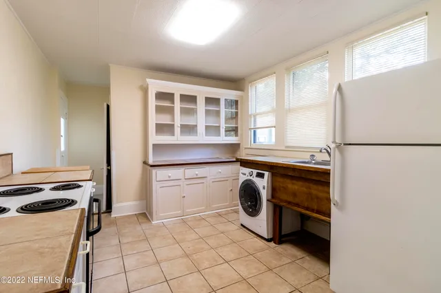 a kitchen with granite countertop white cabinets and white appliances
