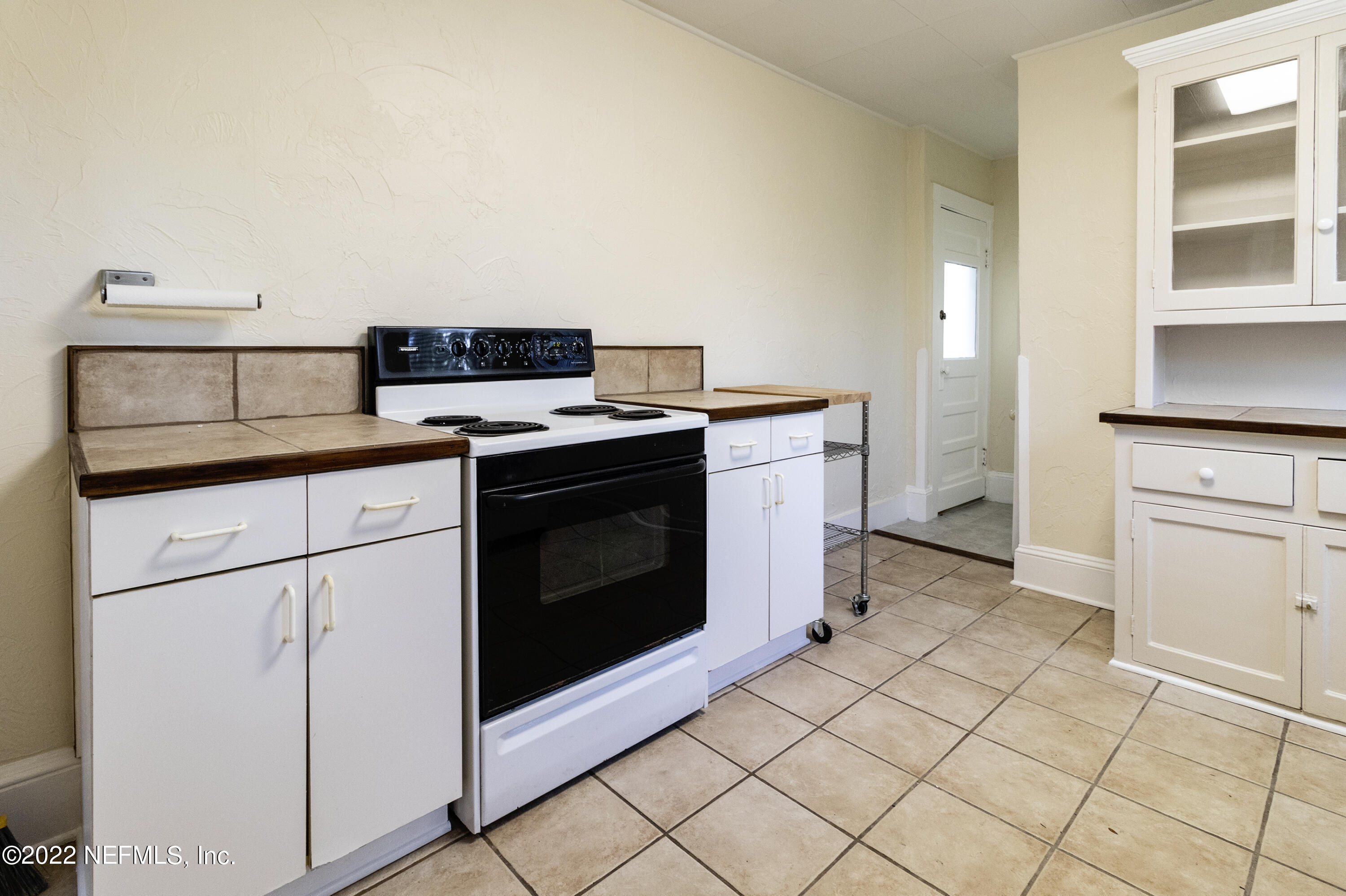 24 Riberia Street, Unit B St. Augustine, FL 32084 - Photo 15 of 19 a kitchen with granite countertop white cabinets and white appliances