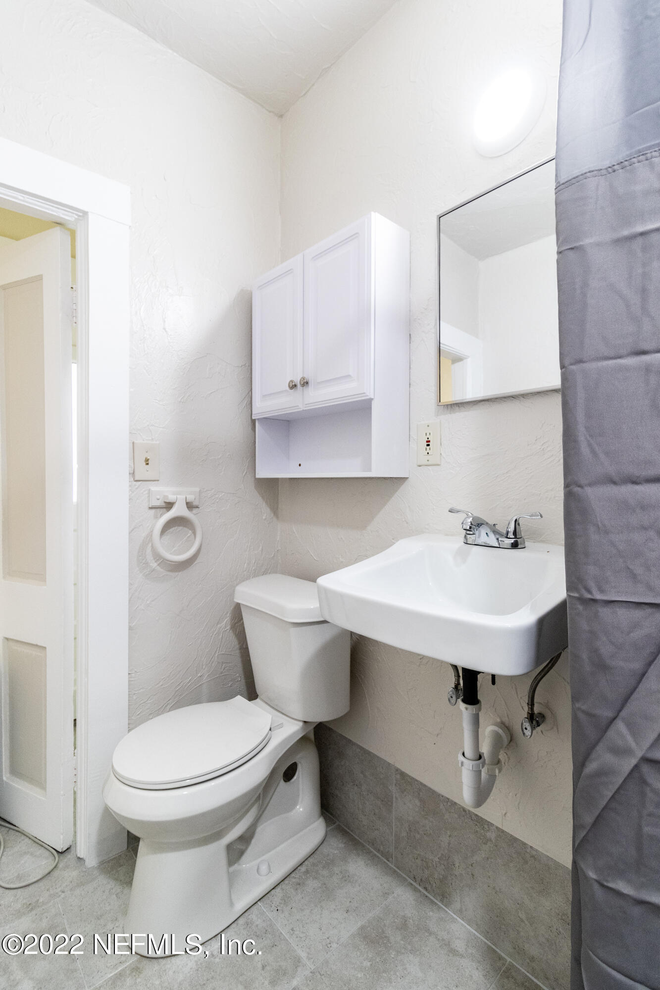 24 Riberia Street, Unit B St. Augustine, FL 32084 - Photo 18 of 19 a bathroom with a sink a toilet and a mirror