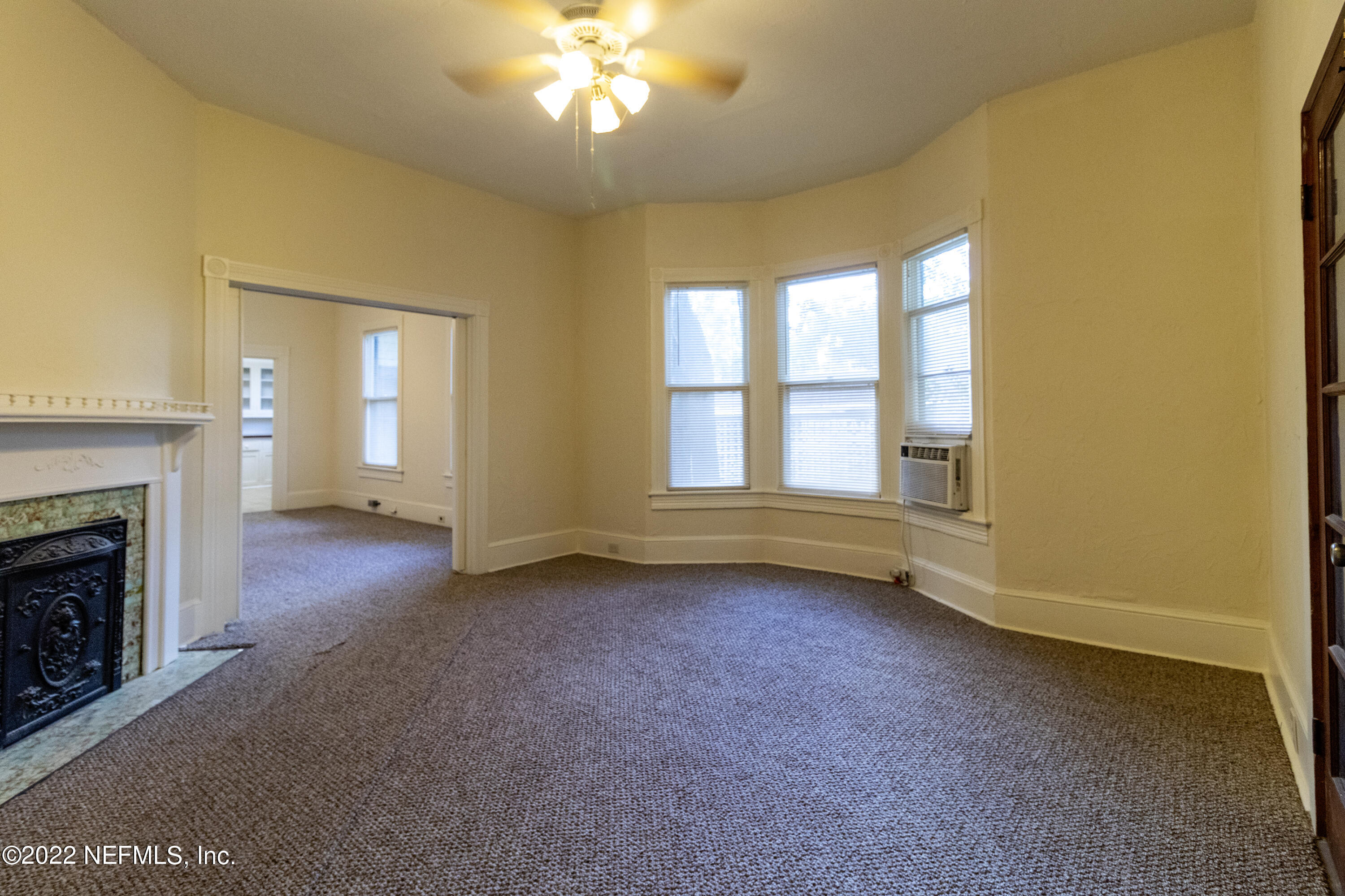 24 Riberia Street, Unit B St. Augustine, FL 32084 - Photo 3 of 19 a view of an empty room with a fireplace and a window