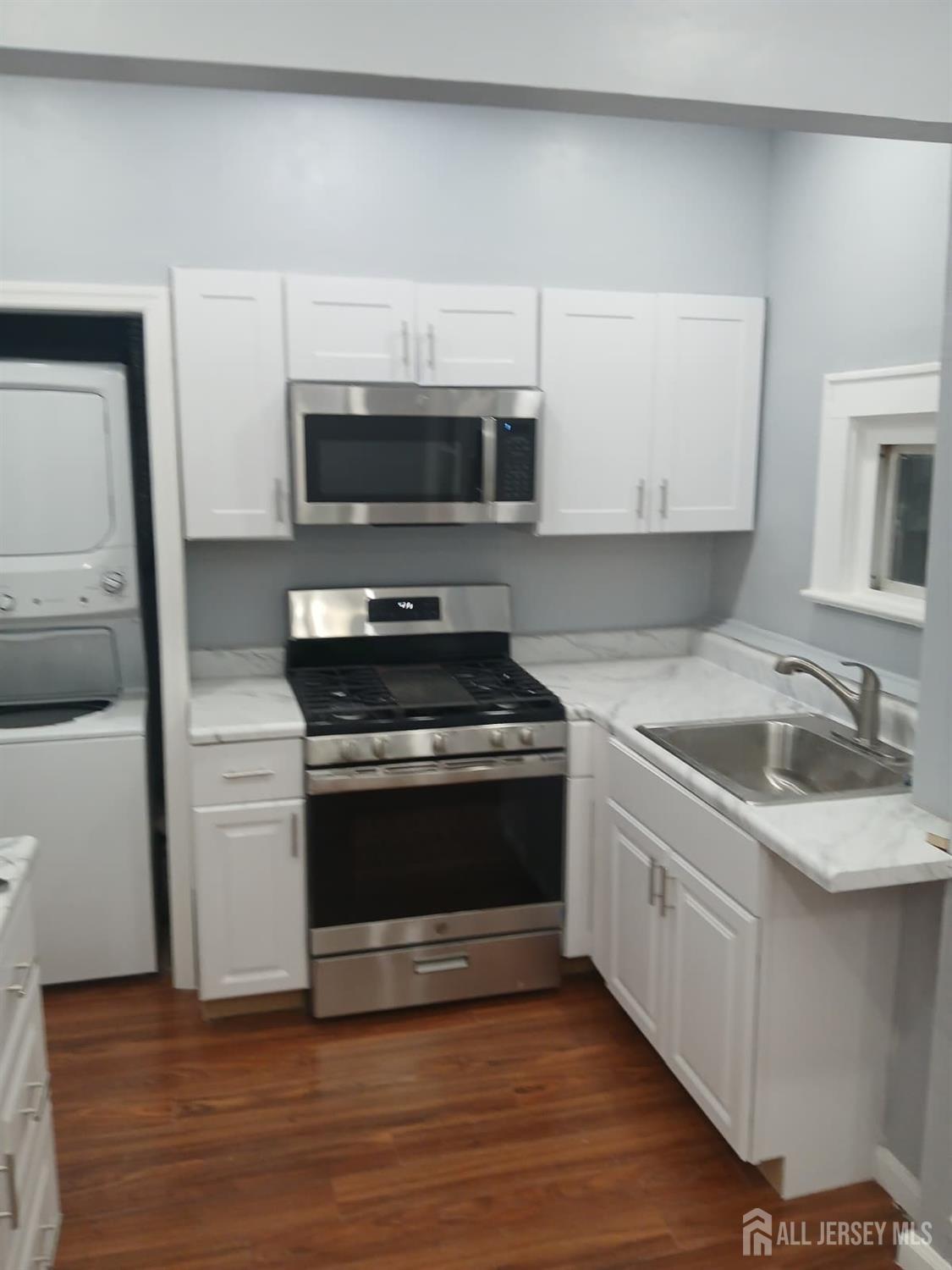 51 Poe Avenue, Unit 3 Newark, NJ 07106 - Photo 5 of 14 a kitchen with stainless steel appliances granite countertop a stove a sink and a microwave