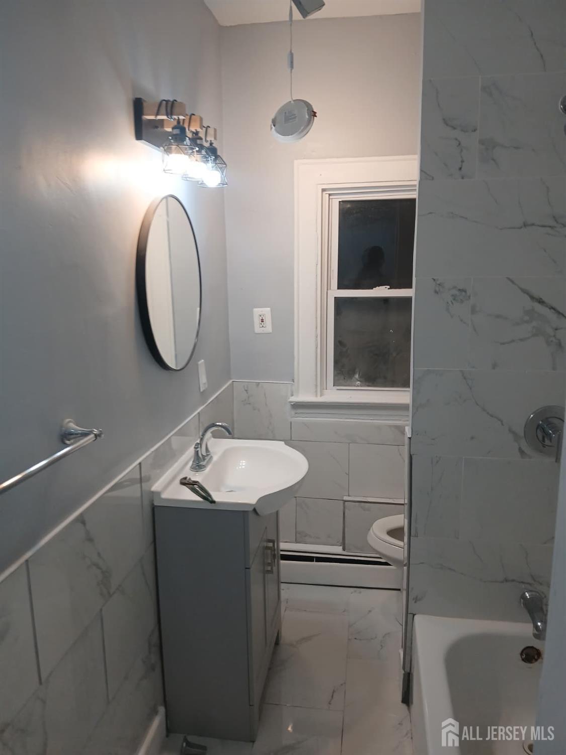 51 Poe Avenue, Unit 3 Newark, NJ 07106 - Photo 7 of 14 a bathroom with a sink and a mirror