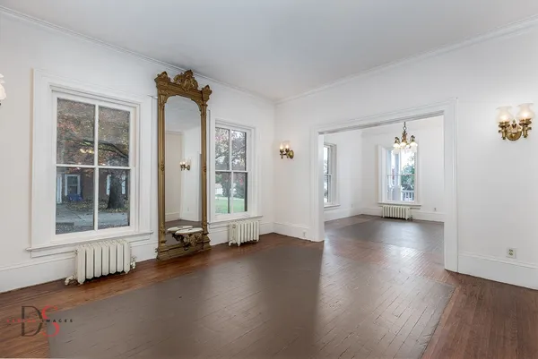 an empty room with wooden floor and windows