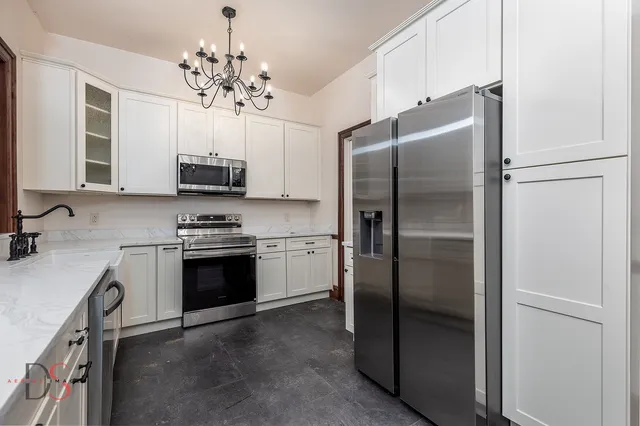 a kitchen with kitchen island a counter top space stainless steel appliances and cabinets