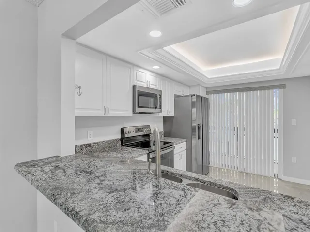 a kitchen with granite countertop cabinets and refrigerator