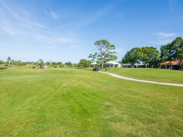 a view of a big yard with a house in the background