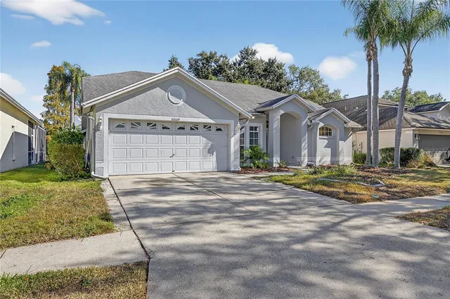 a view of a house with a yard and palm trees