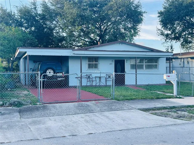 a view of a house with a yard and large tree