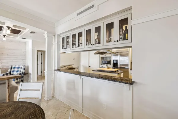 a kitchen with stainless steel appliances kitchen island granite countertop a refrigerator and a sink
