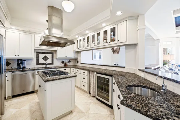 a kitchen with kitchen island a counter space a sink stainless steel appliances and cabinets