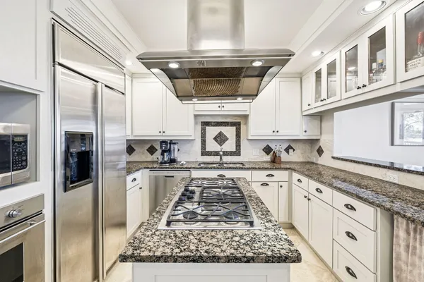 a kitchen with stainless steel appliances granite countertop a stove and a sink