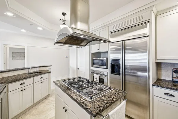 a large kitchen with stainless steel appliances granite countertop a stove sink and cabinets
