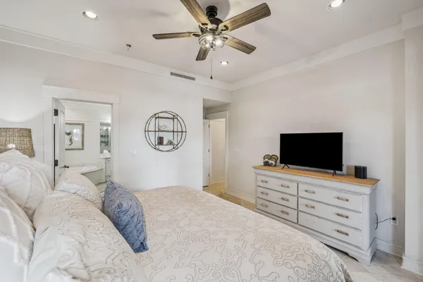 a bedroom with a bed and a flat tv screen on the dresser