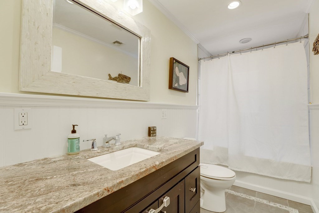 7-9 Goodway Road, Unit 2 Boston, MA 02130 - Photo 16 of 33 a bathroom with a granite countertop sink a toilet and a mirror