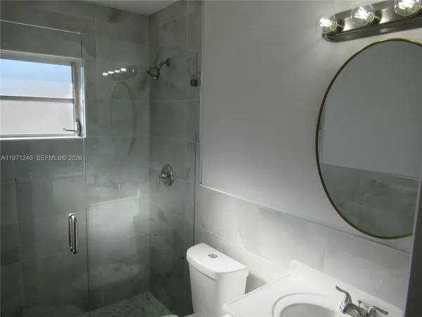 a bathroom with a granite countertop sink mirror and a toilet