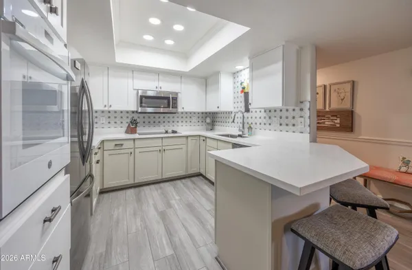a kitchen with a sink a stove cabinets and a dining table