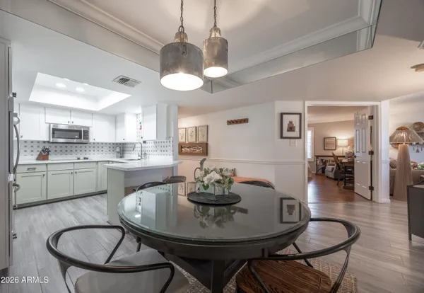a view of a dining room with furniture a chandelier and wooden floor
