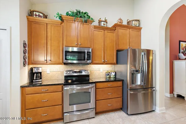 a kitchen with appliances a refrigerator and cabinets