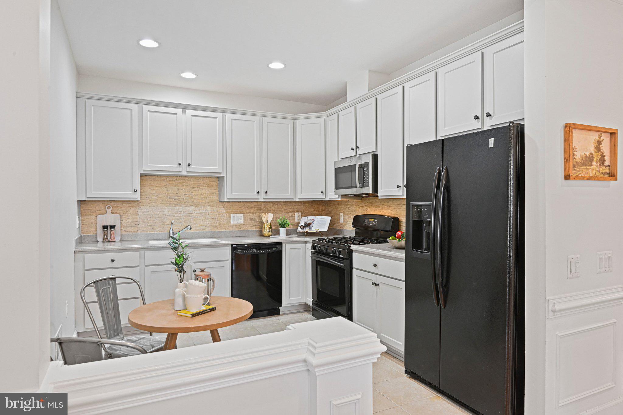 44482 Maltese Falcon Square Ashburn, VA 20147 - Photo 11 of 71 a kitchen with stainless steel appliances kitchen island granite countertop a refrigerator and a stove top oven