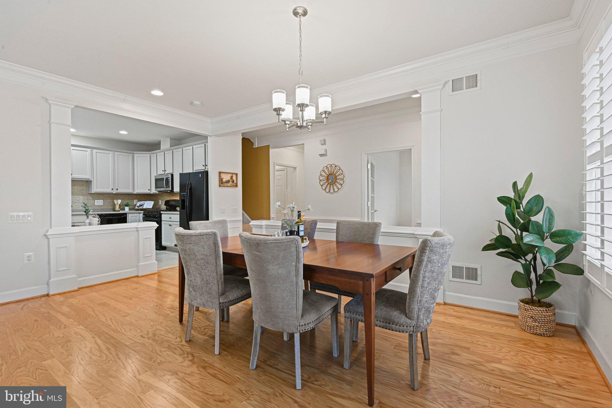 44482 Maltese Falcon Square Ashburn, VA 20147 - Photo 9 of 71 a view of a dining room with furniture a chandelier and wooden floor