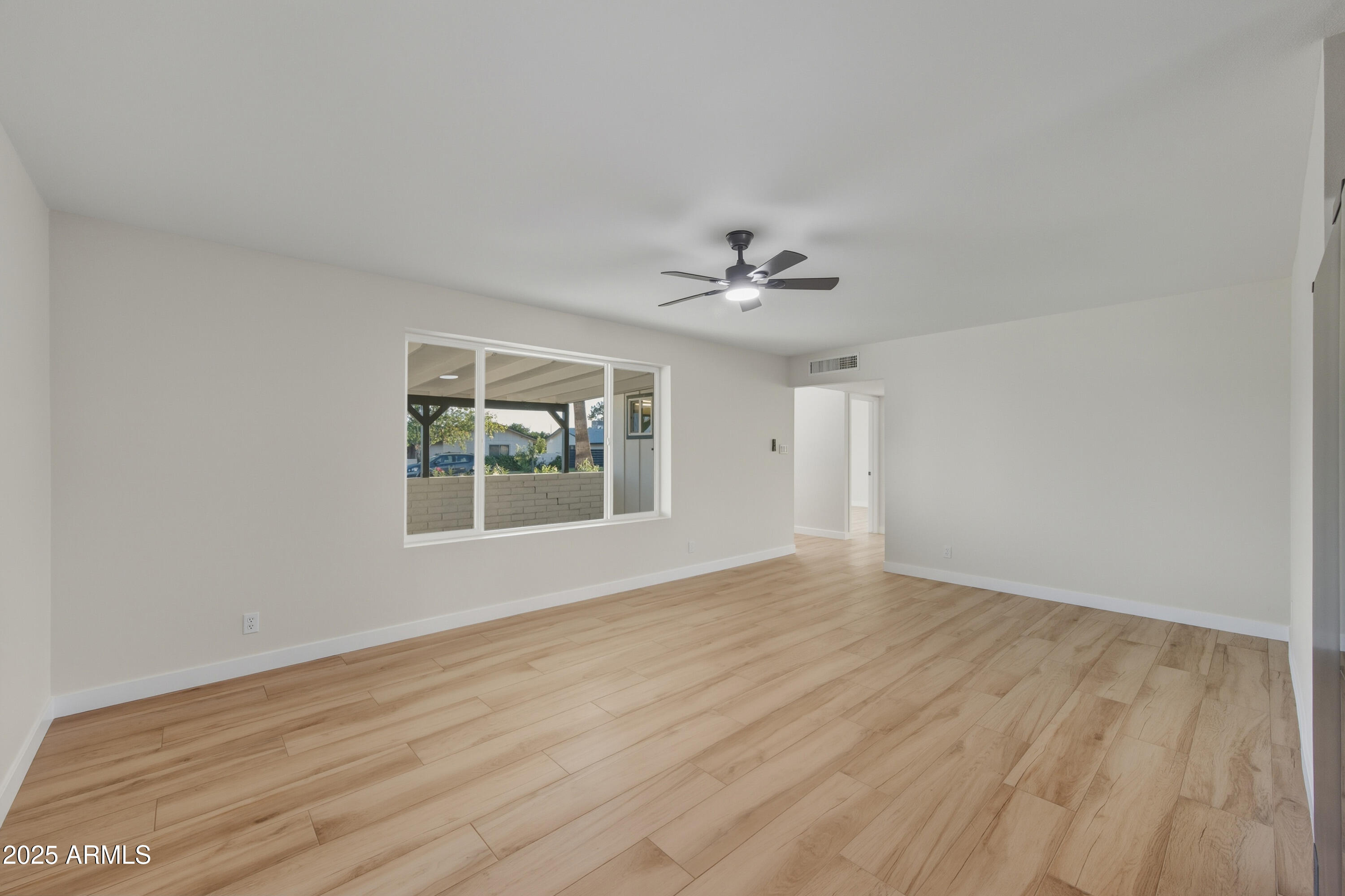 3410 West Pershing Avenue Phoenix, AZ 85029 - Photo 11 of 33 a view of an empty room with wooden floor and a window