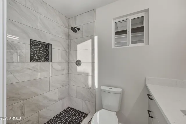 a bathroom with a toilet and a shower