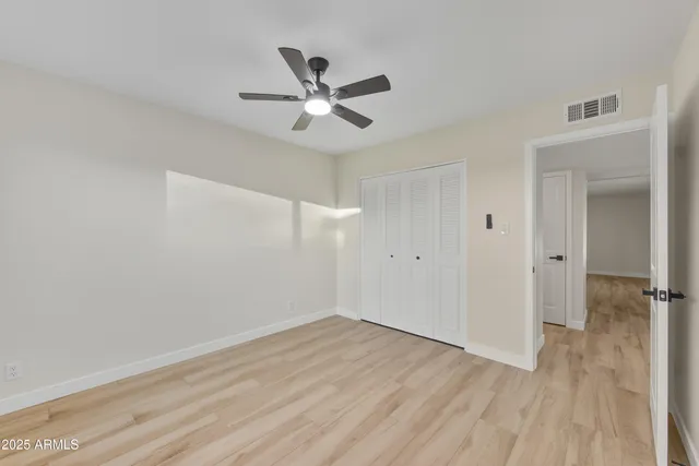 a view of a room with wooden floor and a ceiling fan
