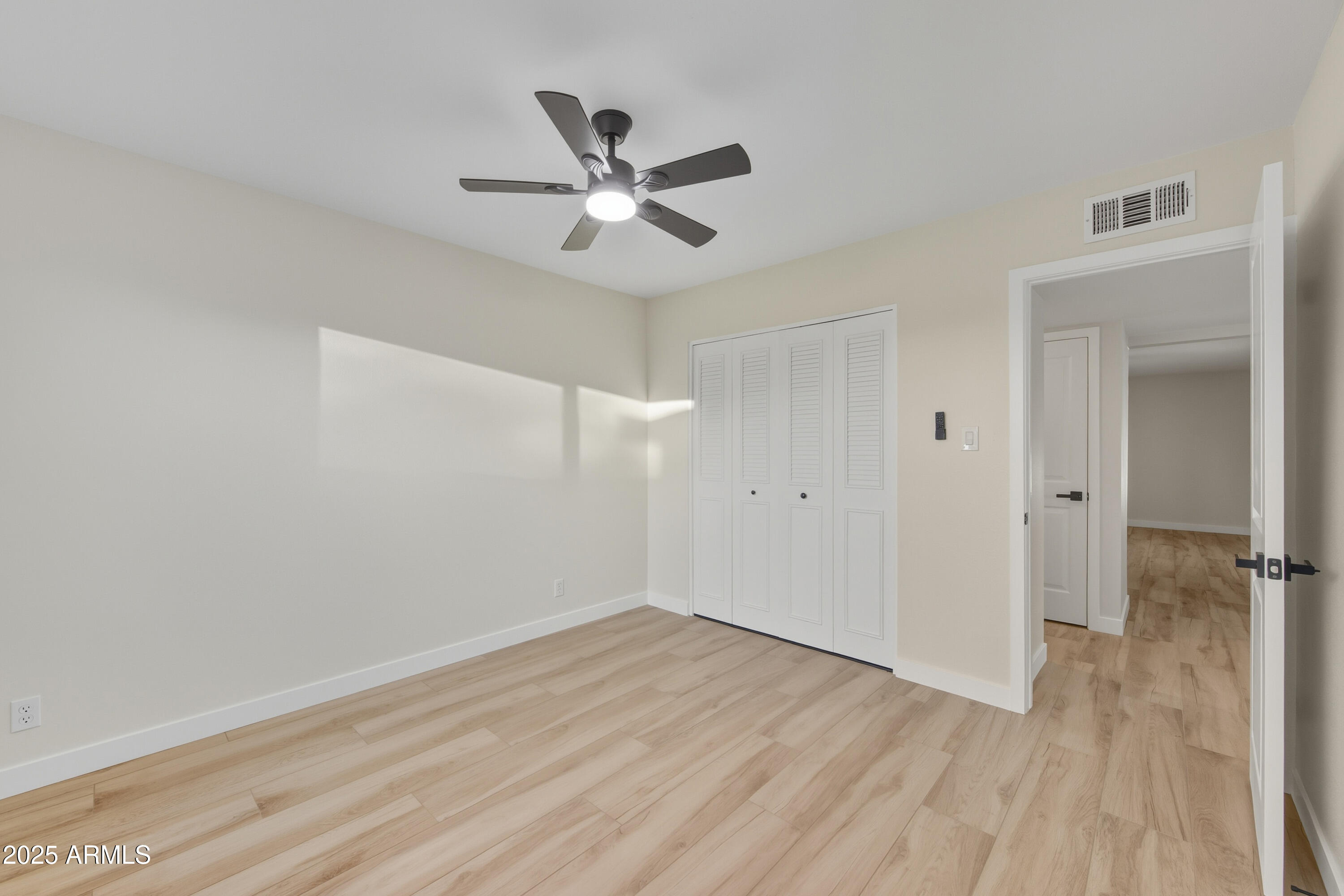 3410 West Pershing Avenue Phoenix, AZ 85029 - Photo 17 of 33 a view of a room with wooden floor and a ceiling fan