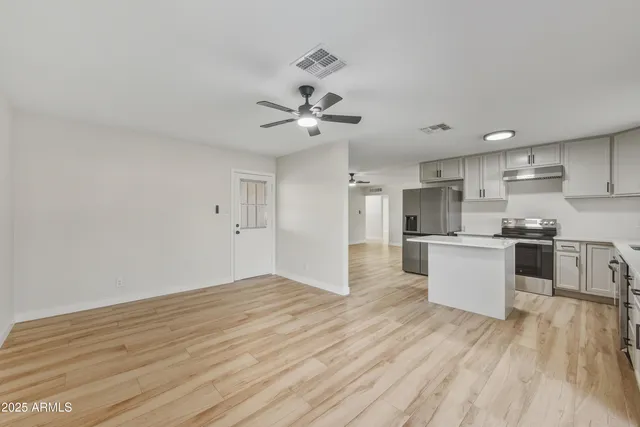 a view of kitchen with refrigerator microwave and stove