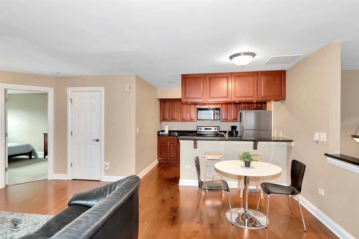 43 Foxcroft Road, Unit 219 Naperville, IL 60565 - Photo 3 of 19 a kitchen with a dining table chairs and sink