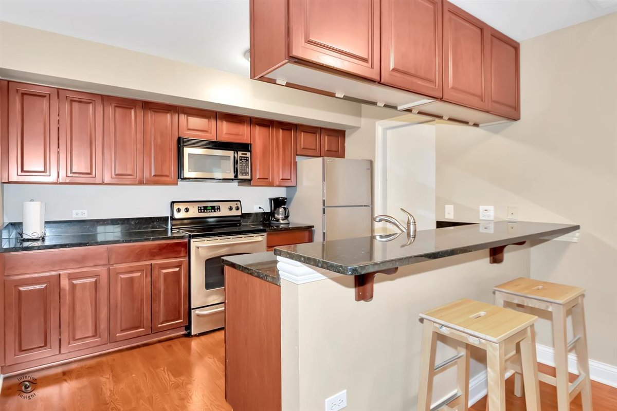 43 Foxcroft Road, Unit 219 Naperville, IL 60565 - Photo 7 of 19 a kitchen with stainless steel appliances granite countertop a refrigerator sink stove and microwave