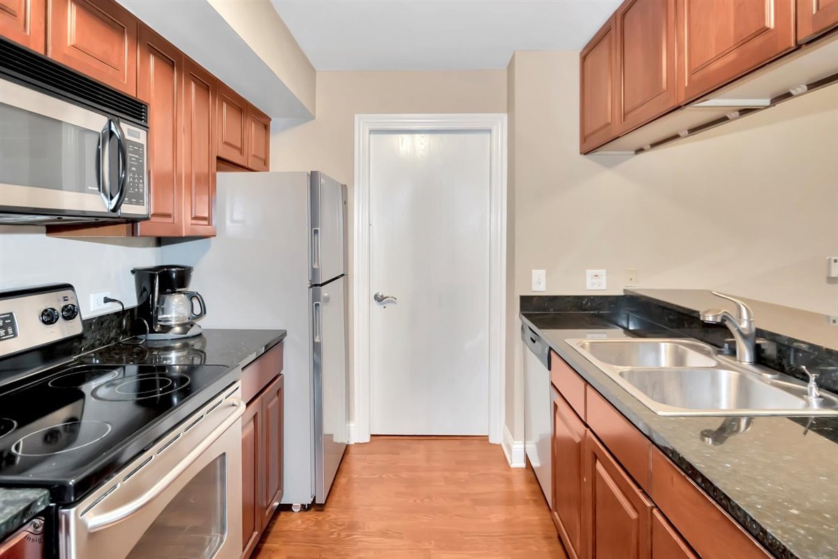 43 Foxcroft Road, Unit 219 Naperville, IL 60565 - Photo 8 of 19 a kitchen with stainless steel appliances granite countertop a sink stove and refrigerator