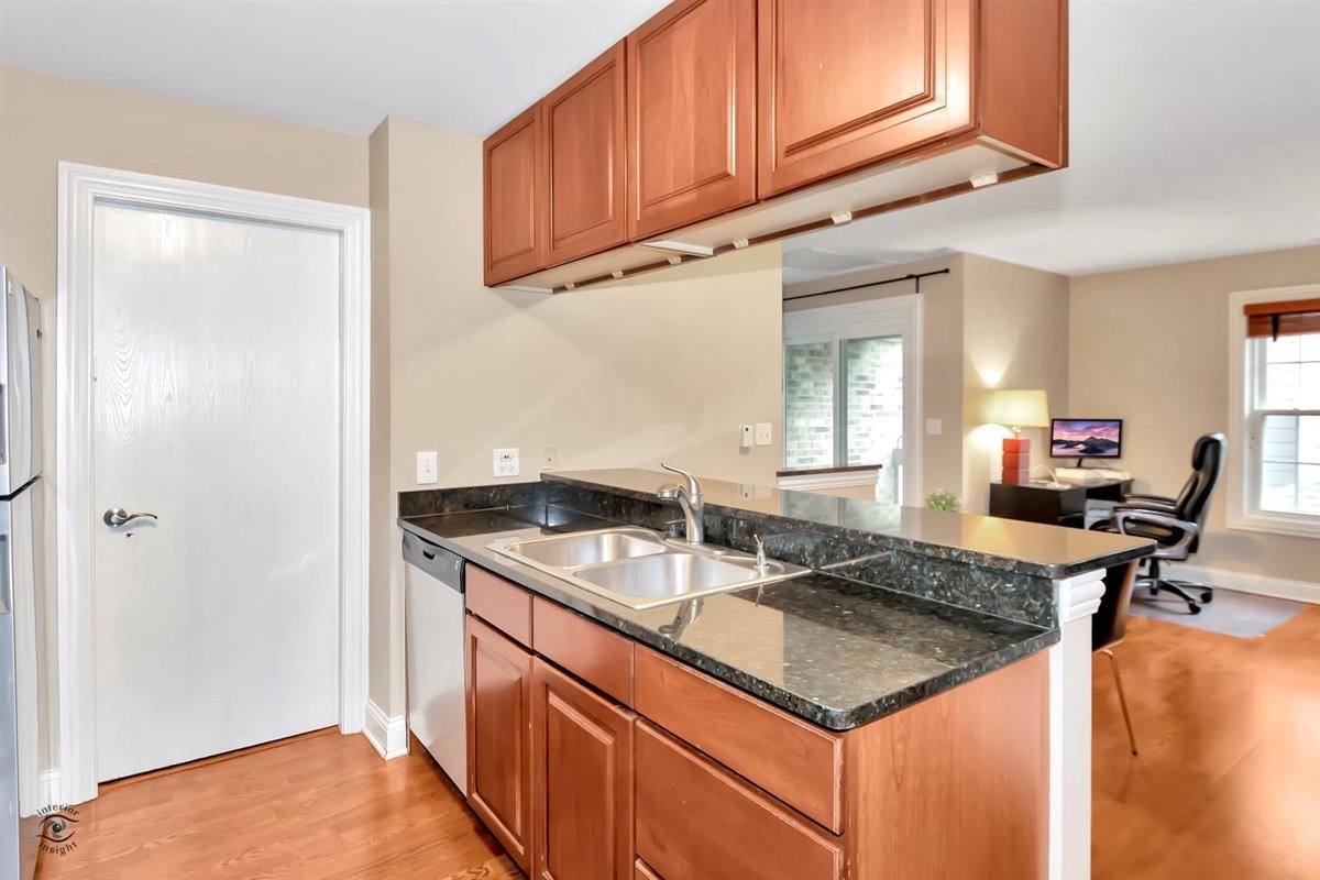 43 Foxcroft Road, Unit 219 Naperville, IL 60565 - Photo 9 of 19 a kitchen with granite countertop a sink a stove and a refrigerator
