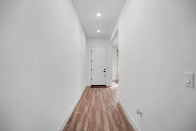 a view of a hallway with wooden floor
