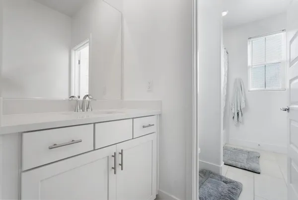 a bathroom with a shower sink and mirror