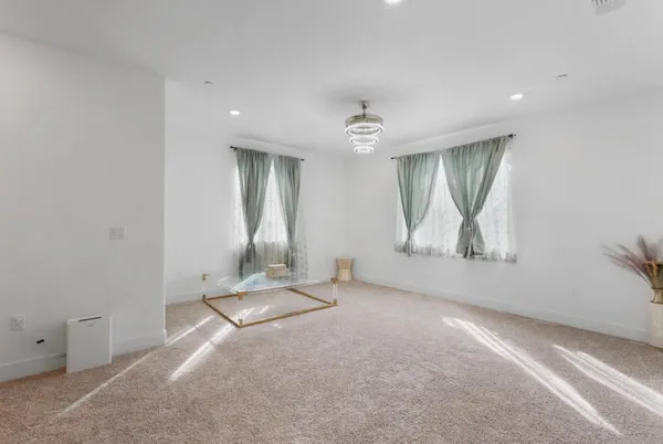an empty room with a fireplace and mirror