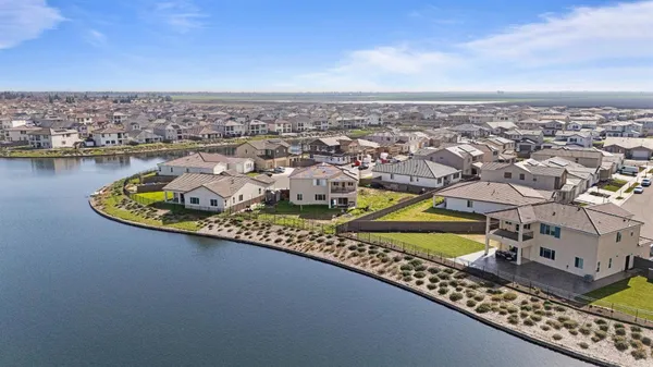 an aerial view of residential houses with outdoor space and ocean view