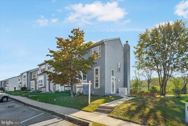 a view of a house with a big yard and large trees