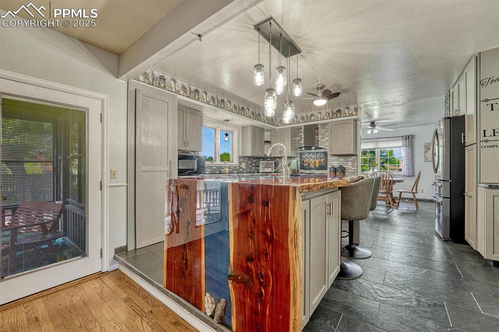 4307 Valli Vista Road Colorado Springs, CO 80915 - Photo 15 of 47 a dining hall with stainless steel appliances kitchen island granite countertop a refrigerator and a sink