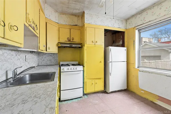 a kitchen with a refrigerator a sink and a cabinets