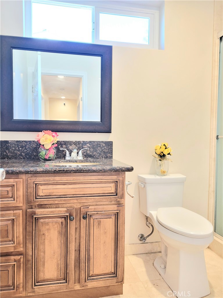 11896 Firebrand Circle Garden Grove, CA 92840 - Photo 18 of 37 a bathroom with a toilet a sink and a mirror