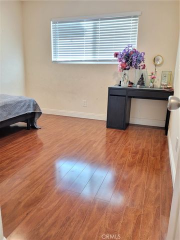 a view of a room with wooden floor and a potted plant