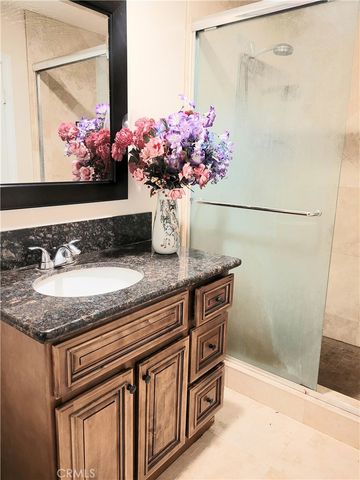 a bathroom with a granite countertop sink a mirror and a shower