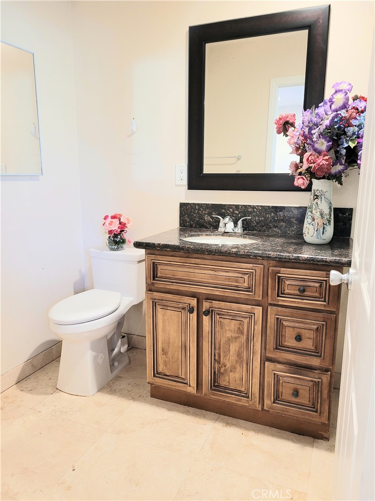 11896 Firebrand Circle Garden Grove, CA 92840 - Photo 22 of 37 a bathroom with a toilet a sink and a mirror