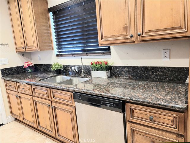 a kitchen with stainless steel appliances granite countertop a sink and a white cabinets